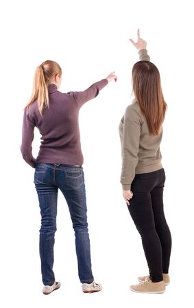Back view of two pointing young girl in sweater. Rear view people collection. backside view of person. beautiful woman friends showing gesture. Rear view. Isolated over white background.の写真素材