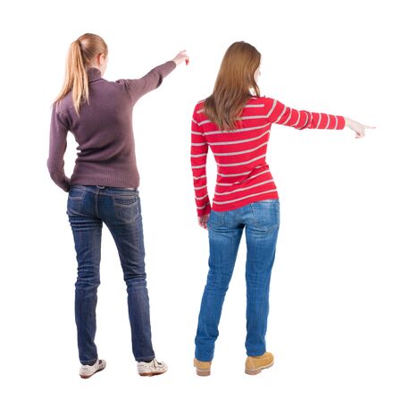 Back view of two pointing young girl in sweater. Rear view people collection. backside view of person. beautiful woman friends showing gesture. Rear view. Isolated over white background.の写真素材