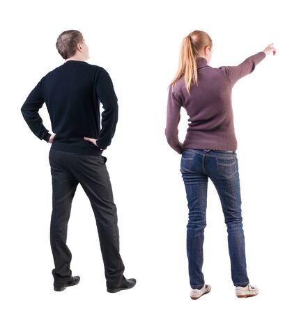 Back view of couple couple in sweater pointing. beautiful friendly girl and guy together. Rear view people collection. backside view of person. Isolated over white background.の写真素材