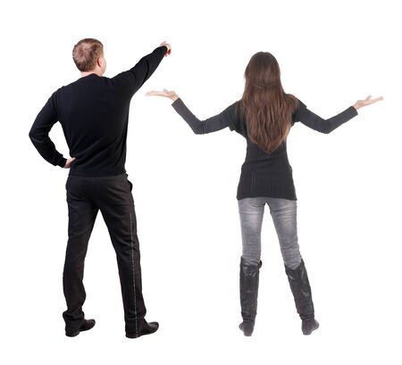 Back view of couple couple in sweater pointing. beautiful friendly girl and guy together. Rear view people collection. backside view of person. Isolated over white background.の写真素材