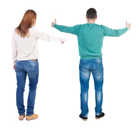 Back view of couple couple in sweater pointing. beautiful friendly girl and guy together. Rear view people collection. backside view of person. Isolated over white background.の写真素材