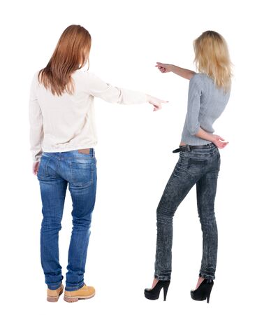 Back view of two pointing young girl in sweater. Rear view people collection. backside view of person. beautiful woman friends showing gesture. Rear view. Isolated over white background.の写真素材