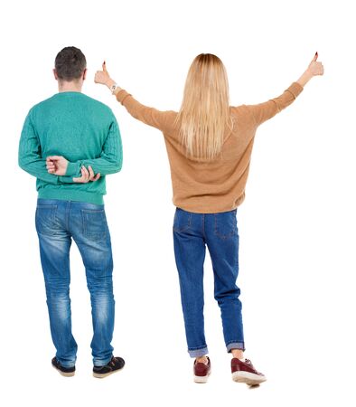 Back view of couple couple in sweater showing thumbs up. beautiful friendly girl and guy together. Rear view people collection. backside view of person. Isolated over white background.の写真素材
