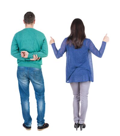 Back view of couple couple in sweater showing thumbs up. beautiful friendly girl and guy together. Rear view people collection. backside view of person. Isolated over white background.の写真素材