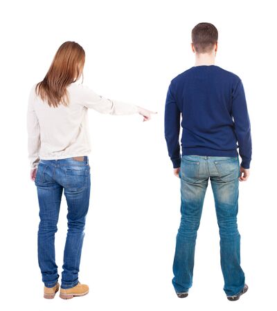 Back view of couple couple in sweater pointing. beautiful friendly girl and guy together. Rear view people collection. backside view of person. Isolated over white background.の写真素材