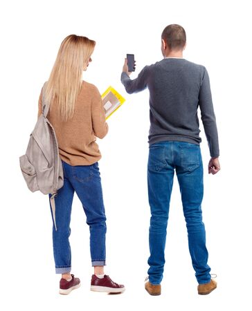 Back view of couple in sweater with mobile phone. beautiful friendly girl and guy together. Rear view people collection. backside view of person. Isolated over white background.の写真素材