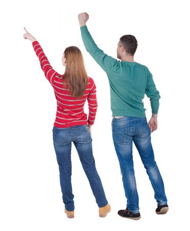 Back view of couple couple in sweater pointing. beautiful friendly girl and guy together. Rear view people collection. backside view of person. Isolated over white background.の写真素材