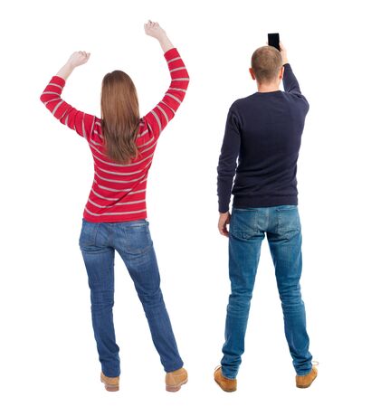 Back view of couple in sweater with mobile phone. beautiful friendly girl and guy together. Rear view people collection. backside view of person. Isolated over white background.の写真素材