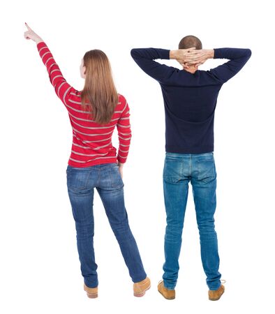 Back view of couple couple in sweater pointing. beautiful friendly girl and guy together. Rear view people collection. backside view of person. Isolated over white background.の写真素材