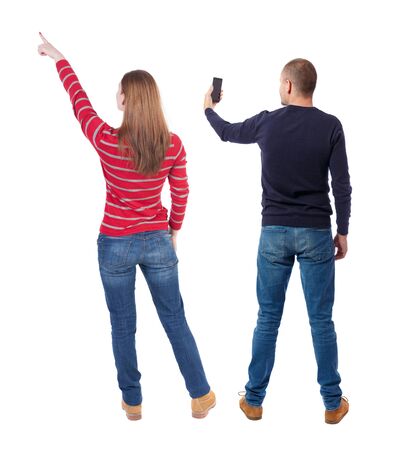 Back view of couple in sweater with mobile phone. beautiful friendly girl and guy together. Rear view people collection. backside view of person. Isolated over white background.の写真素材