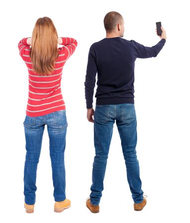 Back view of couple in sweater with mobile phone. beautiful friendly girl and guy together. Rear view people collection. backside view of person. Isolated over white background.の写真素材