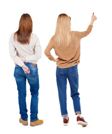 Back view of two young girl in sweater showing thumb up. Rear view people collection. backside view of person. beautiful woman friends showing gesture. Rear view. Isolated over white background.の写真素材