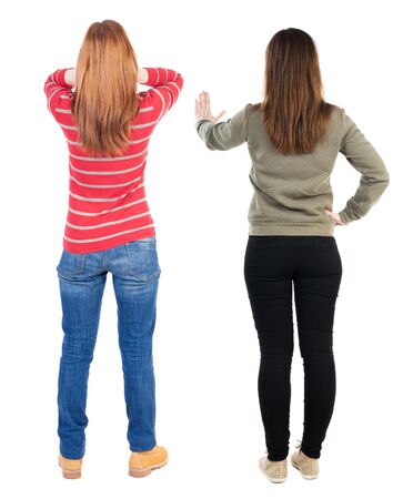 Back view of two pointing young girl in sweater. Rear view people collection. backside view of person. beautiful woman friends showing gesture. Rear view. Isolated over white background.の写真素材