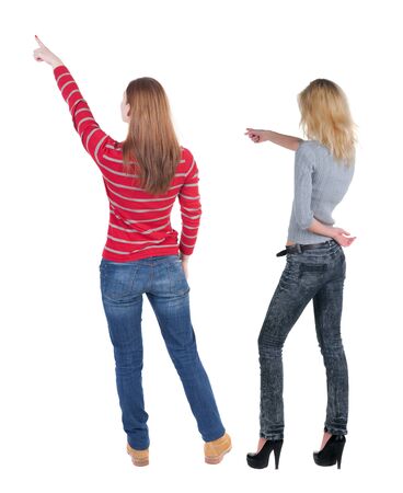 Back view of two pointing young girl in sweater. Rear view people collection. backside view of person. beautiful woman friends showing gesture. Rear view. Isolated over white background.の写真素材