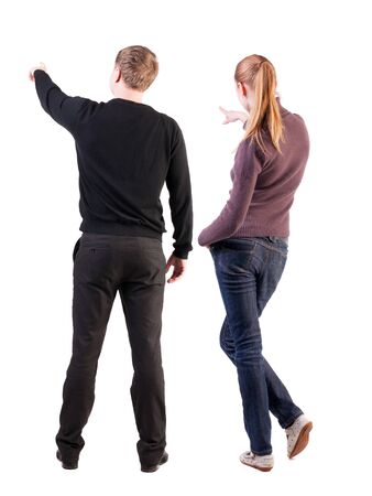 Back view of couple couple in sweater pointing. beautiful friendly girl and guy together. Rear view people collection. backside view of person. Isolated over white background.の写真素材