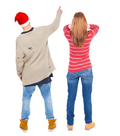 Back view of couple couple in sweater pointing. beautiful friendly girl and guy together. Rear view people collection. backside view of person. Isolated over white background.の写真素材