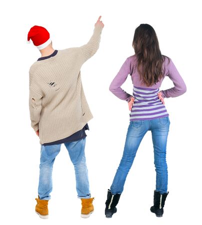 Back view of couple couple in sweater pointing. beautiful friendly girl and guy together. Rear view people collection. backside view of person. Isolated over white background.の写真素材