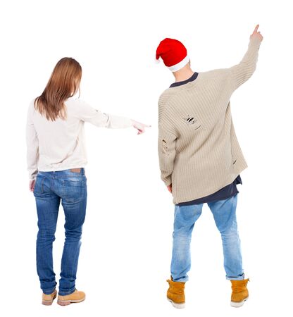 Back view of couple couple in sweater pointing. beautiful friendly girl and guy together. Rear view people collection. backside view of person. Isolated over white background.の写真素材