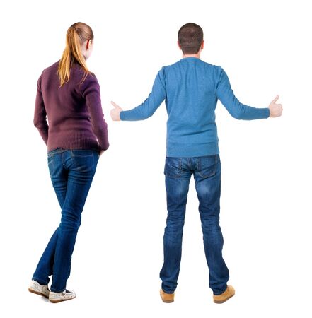 Back view of couple couple in sweater showing thumbs up. beautiful friendly girl and guy together. Rear view people collection. backside view of person. Isolated over white background.の写真素材