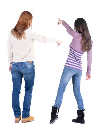 Back view of two pointing young girl in sweater. Rear view people collection. backside view of person. beautiful woman friends showing gesture. Rear view. Isolated over white background.の写真素材