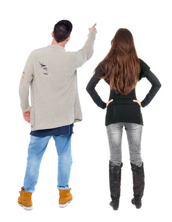 Back view of couple couple in sweater pointing. beautiful friendly girl and guy together. Rear view people collection. backside view of person. Isolated over white background.の写真素材