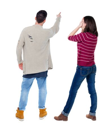 Back view of couple couple in sweater pointing. beautiful friendly girl and guy together. Rear view people collection. backside view of person. Isolated over white background.の写真素材
