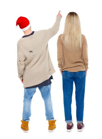 Back view of couple couple in sweater pointing. beautiful friendly girl and guy together. Rear view people collection. backside view of person. Isolated over white background.の写真素材