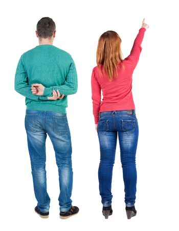 Back view of couple couple in sweater pointing. beautiful friendly girl and guy together. Rear view people collection. backside view of person. Isolated over white background.の写真素材