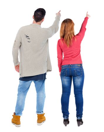 Back view of couple couple in sweater pointing. beautiful friendly girl and guy together. Rear view people collection. backside view of person. Isolated over white background.の写真素材