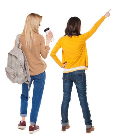 Back view of two pointing young girl in sweater. Rear view people collection. backside view of person. beautiful woman friends showing gesture. Rear view. Isolated over white background.の写真素材