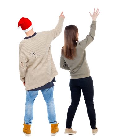 Back view of couple couple in sweater pointing. beautiful friendly girl and guy together. Rear view people collection. backside view of person. Isolated over white background.の写真素材