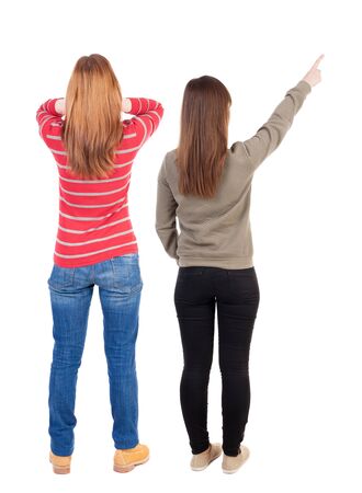 Back view of two pointing young girl in sweater. Rear view people collection. backside view of person. beautiful woman friends showing gesture. Rear view. Isolated over white background.の写真素材