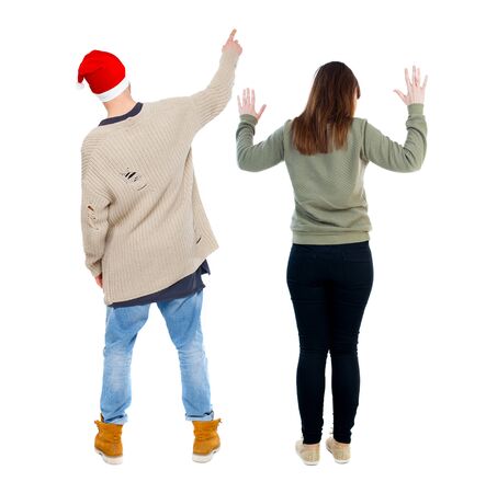 Back view of couple couple in sweater pointing. beautiful friendly girl and guy together. Rear view people collection. backside view of person. Isolated over white background.の写真素材
