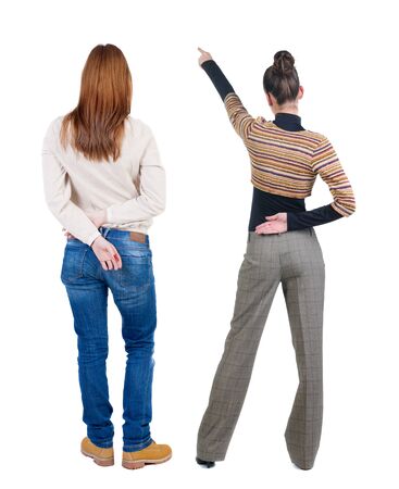 Back view of two pointing young girl in sweater. Rear view people collection. backside view of person. beautiful woman friends showing gesture. Rear view. Isolated over white background.の写真素材