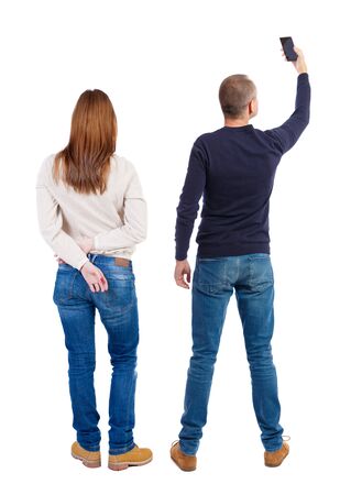 Back view of couple in sweater with mobile phone. beautiful friendly girl and guy together. Rear view people collection. backside view of person. Isolated over white background.の写真素材