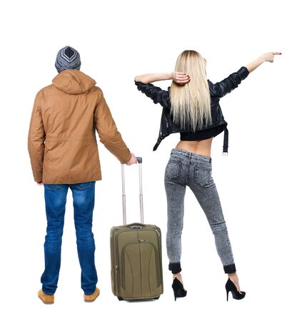 young couple in winter jacket traveling with suitcas. Back view. Rear view people collection. backside view of person. Isolated over white background.の写真素材