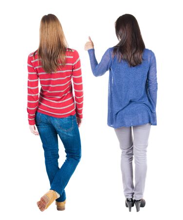 Back view of two woman in sweater showing thumb up. Rear view people collection. backside view of person. Rear view. Isolated over white background.の写真素材