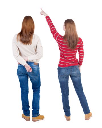 Back view of two pointing girl in sweater. Rear view people collection. backside view of person. beautiful woman showing gesture. Rear view. Isolated over white background.の写真素材