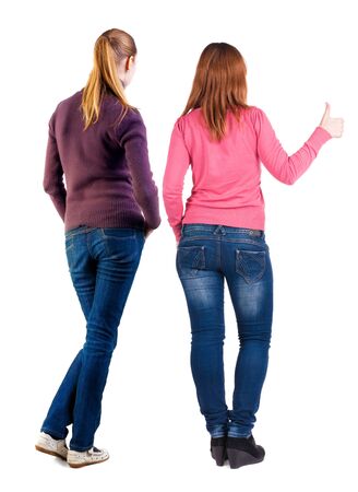 Back view of two woman in sweater showing thumb up. Rear view people collection. backside view of person. Rear view. Isolated over white background.の写真素材