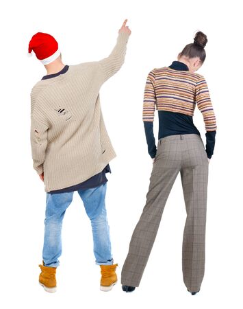 Back view of couple couple in sweater pointing. Rear view people collection. backside view of person. Isolated over white background.の写真素材