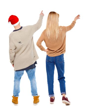 Back view of couple couple in sweater pointing. Rear view people collection. backside view of person. Isolated over white background.の写真素材