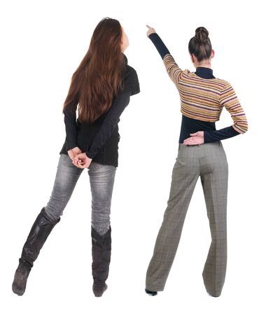 Back view of two pointing girl in sweater. Rear view people collection. backside view of person. beautiful woman showing gesture. Rear view. Isolated over white background.の写真素材
