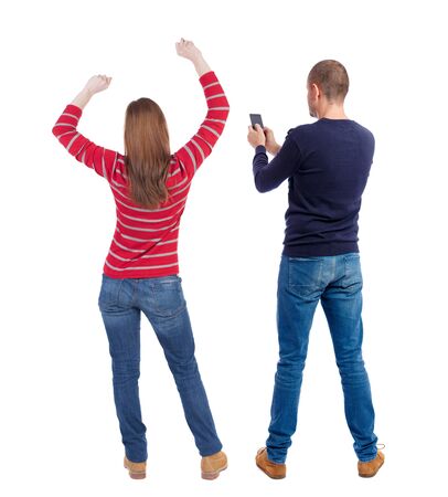 Back view of couple in sweater with mobile phone. Rear view people collection. backside view of person. Isolated over white background.の写真素材