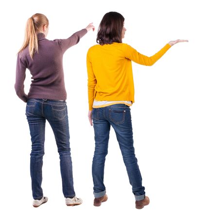 Back view of two pointing girl in sweater. Rear view people collection. backside view of person. beautiful woman showing gesture. Rear view. Isolated over white background.の写真素材
