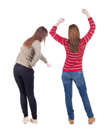 Back view of two pointing girl in sweater. Rear view people collection. backside view of person. beautiful woman showing gesture. Rear view. Isolated over white background.の写真素材