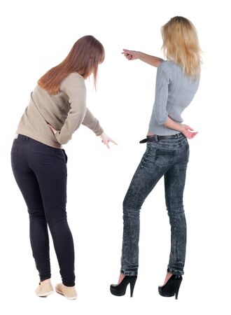 Back view of two pointing girl in sweater. Rear view people collection. backside view of person. beautiful woman showing gesture. Rear view. Isolated over white background.の写真素材
