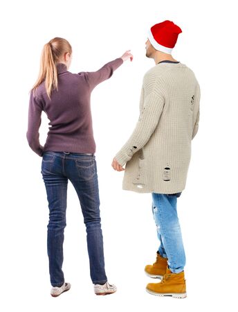 Back view of couple in sweater pointing. Rear view people collection. backside view of person. Isolated over white background.の写真素材