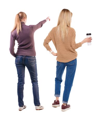 Back view of two pointing girl in sweater. Rear view people collection. backside view of person. beautiful woman showing gesture. Rear view. Isolated over white background.の写真素材