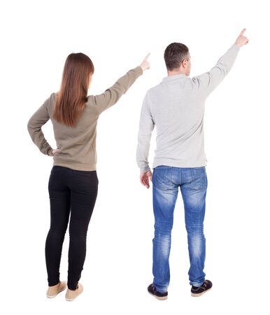 Back view of couple in sweater pointing. Rear view people collection. backside view of person. Isolated over white background.の写真素材