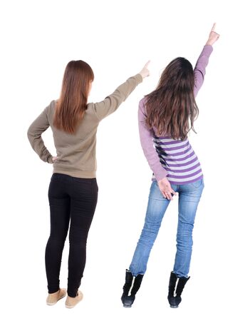 Back view of two pointing girl in sweater. Rear view people collection. backside view of person. beautiful woman showing gesture. Rear view. Isolated over white background.の写真素材